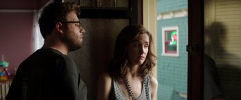 Movie still from “Neighbors” (2014), directed by Nicholas Stoller – A man and a woman standing next to each other near a window; Medium shot, Over the shoulder angle