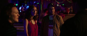 Movie still from “Neighbors” (2014), directed by Nicholas Stoller – A man and a woman standing next to each other in a room; Medium shot, Over the shoulder angle