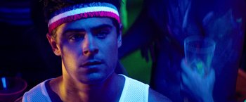 Movie still from “Neighbors” (2014), directed by Nicholas Stoller – A person wearing a headband; Close Up shot, Over the shoulder angle