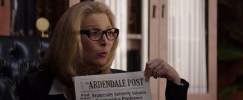 Movie still from “Neighbors” (2014), directed by Nicholas Stoller – A woman holding up a newspaper in front of her face; Close Up shot, Over the shoulder angle