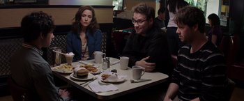 Movie still from “Neighbors” (2014), directed by Nicholas Stoller – A man and a woman sitting at a table with food; Medium shot, Over the shoulder angle