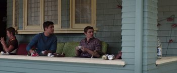 Movie still from “Neighbors” (2014), directed by Nicholas Stoller – A man sitting on top of a bench holding a coffee cup; Medium shot, Low angle