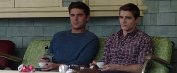 Movie still from “Neighbors” (2014), directed by Nicholas Stoller – Two young men sitting at a table drinking coffee; Medium shot, Over the shoulder angle