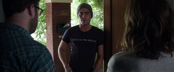 Movie still from “Neighbors” (2014), directed by Nicholas Stoller – A man wearing a hat standing in front of a door; Medium shot, Over the shoulder angle