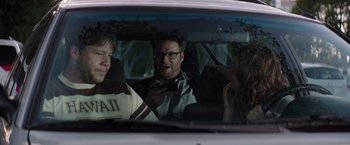 Movie still from “Neighbors” (2014), directed by Nicholas Stoller – Three people sitting in the back seat of a car; Medium shot, Over the shoulder angle