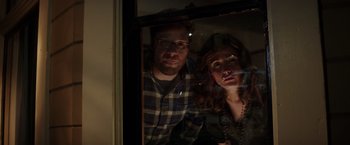 Movie still from “Neighbors” (2014), directed by Nicholas Stoller – A man and a woman looking out of a window; Medium shot, High angle