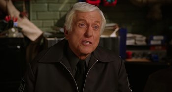 Movie still from “Night at the Museum” (2006), directed by Shawn Levy – An older man in a black jacket and a black tie; Close Up shot, Over the shoulder angle