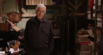 Movie still from “Night at the Museum” (2006), directed by Shawn Levy – An older man standing in front of a fan in a room; Medium shot, Over the shoulder angle