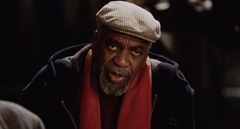 Movie still from “Night at the Museum” (2006), directed by Shawn Levy – An older man wearing a hat and a red scarf; Close Up shot, Low angle