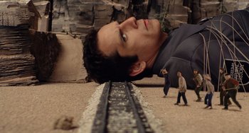 Movie still from “Night at the Museum” (2006), directed by Shawn Levy – A man laying on the ground next to a train track; Medium shot, High angle