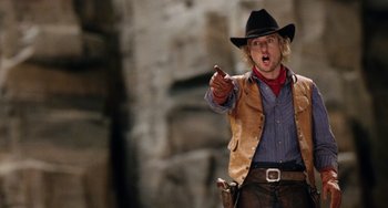 Movie still from “Night at the Museum” (2006), directed by Shawn Levy – A man wearing a cowboy hat and pointing to the side; Medium shot, Over the shoulder angle