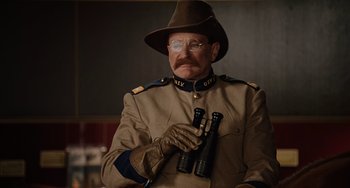 Movie still from “Night at the Museum” (2006), directed by Shawn Levy – A man in a military uniform holding a pair of binoculars; Medium shot, Low angle