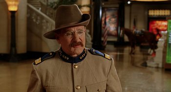Movie still from “Night at the Museum” (2006), directed by Shawn Levy – An older man in a military uniform wearing a hat and eye glasses; Medium shot, Over the shoulder angle