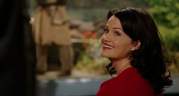 Movie still from “Night at the Museum” (2006), directed by Shawn Levy – A woman in a red shirt smiling for the camera; Close Up shot, Over the shoulder angle