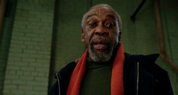 Movie still from “Night at the Museum” (2006), directed by Shawn Levy – An older man wearing a green shirt and a red scarf; Close Up shot, Low angle