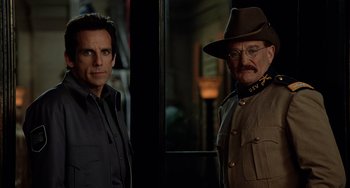 Movie still from “Night at the Museum” (2006), directed by Shawn Levy – Two men standing next to each other in front of a window; Medium shot, Over the shoulder angle