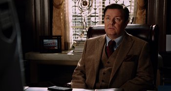 Movie still from “Night at the Museum” (2006), directed by Shawn Levy – A man sitting at a desk wearing a suit and tie; Medium shot, Over the shoulder angle