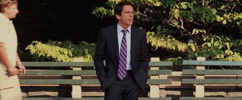 Movie still from “Night at the Museum: Battle of the Smithsonian” (2009), directed by Shawn Levy – A man in a suit and tie standing on a park bench; Medium shot, Over the shoulder angle