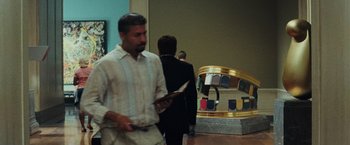 Movie still from “Night at the Museum: Battle of the Smithsonian” (2009), directed by Shawn Levy – A man holding a tablet in a room with other people; Medium shot, Low angle