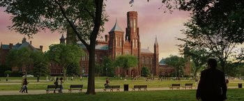Movie still from “Night at the Museum: Battle of the Smithsonian” (2009), directed by Shawn Levy – People are sitting on park benches in front of a large building; Extreme Wide shot, Low angle