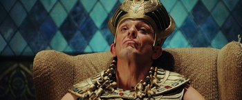 Movie still from “Night at the Museum: Battle of the Smithsonian” (2009), directed by Shawn Levy – A man wearing a gold crown and a gold necklace; Close Up shot, Low angle