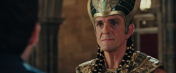 Movie still from “Night at the Museum: Battle of the Smithsonian” (2009), directed by Shawn Levy – An older man wearing a gold and black costume; Close Up shot, Over the shoulder angle
