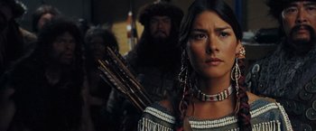 Movie still from “Night at the Museum: Battle of the Smithsonian” (2009), directed by Shawn Levy – A woman holding a bow and arrow while standing next to a man; Close Up shot, Over the shoulder angle