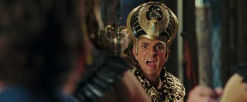 Movie still from “Night at the Museum: Battle of the Smithsonian” (2009), directed by Shawn Levy – A man in a gold and black costume with an egyptian headpiece; Close Up shot, Over the shoulder angle