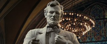 Movie still from “Night at the Museum: Battle of the Smithsonian” (2009), directed by Shawn Levy – A statue of abraham lincoln is shown in a building; Close Up shot, Low angle