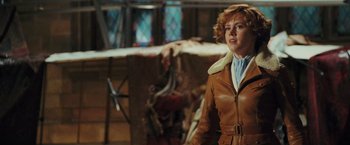 Movie still from “Night at the Museum: Battle of the Smithsonian” (2009), directed by Shawn Levy – A woman in a brown leather jacket standing next to an airplane; Medium shot, Over the shoulder angle