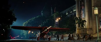 Movie still from “Night at the Museum: Battle of the Smithsonian” (2009), directed by Shawn Levy – People walking near a red and white airplane; Extreme Wide shot, Low angle