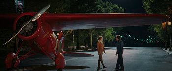 Movie still from “Night at the Museum: Battle of the Smithsonian” (2009), directed by Shawn Levy – Two people walking on the street in front of an airplane; Wide shot, Over the shoulder angle