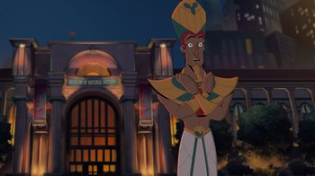 Movie still from “Night at the Museum: Kahmunrah Rises Again” (2022), directed by Justin Lovell – An animated character is standing in front of a building at night; Medium shot, Over the shoulder angle