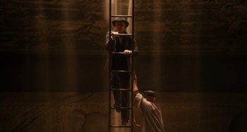 Movie still from “Night at the Museum: Secret of the Tomb” (2014), directed by Shawn Levy – A man standing on top of a ladder next to another man; Wide shot, Low angle