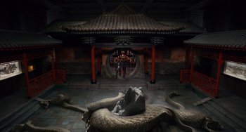 Movie still from “Night at the Museum: Secret of the Tomb” (2014), directed by Shawn Levy – Two people are standing in front of a statue of a snake; Extreme Wide shot, High angle