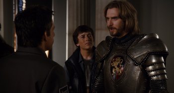 Movie still from “Night at the Museum: Secret of the Tomb” (2014), directed by Shawn Levy – A man in a suit of armor talking to two other men; Medium shot, Over the shoulder angle