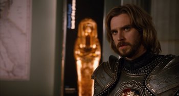 Movie still from “Night at the Museum: Secret of the Tomb” (2014), directed by Shawn Levy – A man wearing a suit of armor standing in front of an egyptian statue; Close Up shot, Over the shoulder angle
