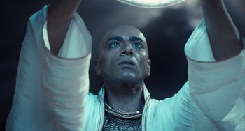 Movie still from “Night at the Museum: Secret of the Tomb” (2014), directed by Shawn Levy – A bald man with a long black beard holding a frisbee in his hands; Close Up shot, Low angle