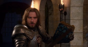 Movie still from “Night at the Museum: Secret of the Tomb” (2014), directed by Shawn Levy – A man dressed as a medieval knight holding a book; Medium shot, Over the shoulder angle