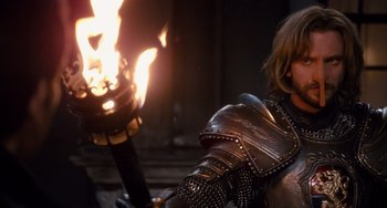 Movie still from “Night at the Museum: Secret of the Tomb” (2014), directed by Shawn Levy – A man in a suit of armor holding a flaming torch; Close Up shot, Over the shoulder angle