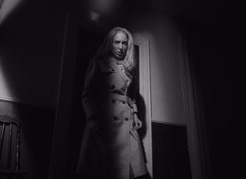 Movie still from “Night of the Living Dead” (1968), directed by George A. Romero – A black and white photo of a woman in a trench coat; Medium shot, Low angle