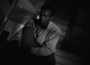 Movie still from “Night of the Living Dead” (1968), directed by George A. Romero – A black and white photo of a man in a suit; Medium shot, High angle