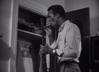 Movie still from “Night of the Living Dead” (1968), directed by George A. Romero – A black and white photo of a man standing in front of an open closet; Medium shot, Low angle