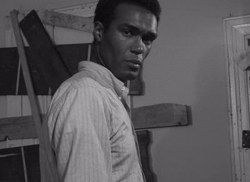 Movie still from “Night of the Living Dead” (1968), directed by George A. Romero – A black and white photo of a man in a striped shirt; Close Up shot, Low angle
