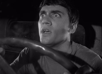 Movie still from “Night of the Living Dead” (1968), directed by George A. Romero – A young man driving a car in the dark; Close Up shot, Low angle