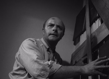 Movie still from “Night of the Living Dead” (1968), directed by George A. Romero – Black and white photograph of a man in a tie; Medium shot, Low angle