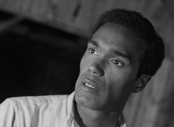 Movie still from “Night of the Living Dead” (1968), directed by George A. Romero – A black and white photo of a man looking at the camera; Close Up shot, Low angle