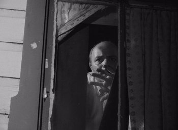 Movie still from “Night of the Living Dead” (1968), directed by George A. Romero – A black and white photo of a man looking out of a window; Close Up shot, Low angle