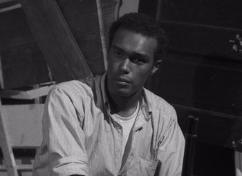 Movie still from “Night of the Living Dead” (1968), directed by George A. Romero – A black and white photo of a man sitting in a chair; Close Up shot, High angle