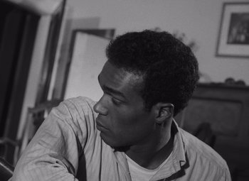 Movie still from “Night of the Living Dead” (1968), directed by George A. Romero – A black and white photo of a man looking to his left; Close Up shot, High angle